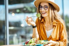 woman-eating-salad-on-a-cafe-terrace-2022-01-18-23-53-34-8THM4EU